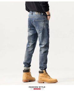 Detailed back view of distressed slim fit denim jeans with a dark leather brand patch