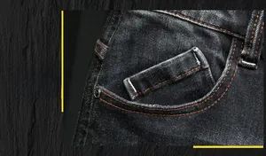Détail de la poche avant d'un jean noir pour homme avec coutures orange contrastées