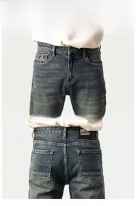 Detail view of retro washed denim jeans featuring back pocket wave embroidery and leather patch