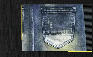 Detail of blue washed denim jeans showing back pocket design and locking zipper puller
