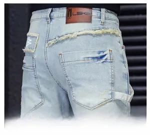 Detail view of light blue distressed jeans showing back pocket and leather brand tag