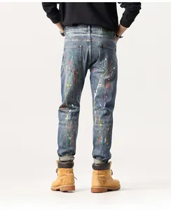 Détail du jean denim avec éclaboussures de peinture colorées et écusson de marque au dos