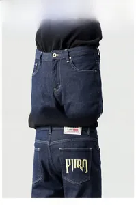 Détails de jeans en denim bleu foncé avec broderie jaune et patch de taille en cuir