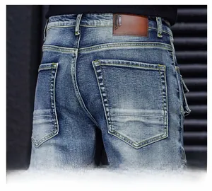 Gros plan de l'écusson en cuir et couture de poche arrière sur jean bleu déchiré homme