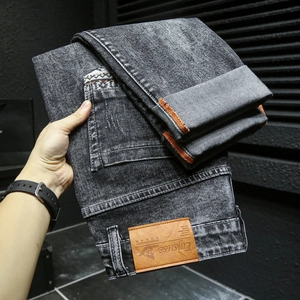 Détail du jean denim avec écusson en cuir vintage et broderies ethniques sur la poche