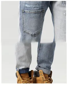 Close-up of distressed denim jeans with patchwork design and vintage embroidery detail