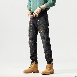 Men's slim fit black distressed denim jeans with colorful paint splatter and ripped details
