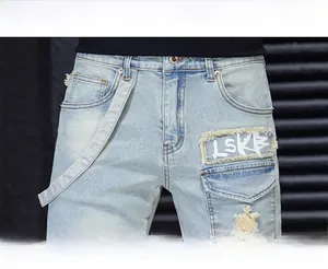 Detail view of denim jeans waist featuring LSKB patch and distressed ripped accents