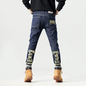 Jean bleu foncé classique avec motifs de crâne jaunes et texte imprimé tendance