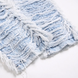 Men's wide leg denim pants with heavy distressed frayed details and long tassels