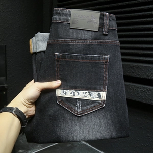 Jean denim gris foncé pour homme avec délavage vintage, effet moustaches et patch en cuir