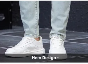 Detailed view of frayed hem design on light blue jeans paired with white sneakers