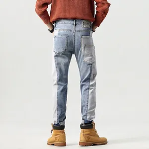 Slim-fit men's color-block patchwork jeans in washed blue denim with utility pockets
