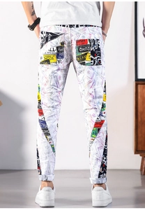 Detail of vintage graffiti print and woven waist tape on slim-fit white street denim jeans