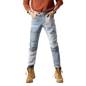 Men's distressed patchwork denim jeans with vintage wash and pocket details in street style