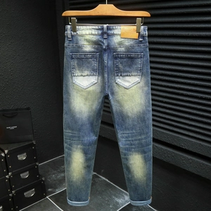 Men's vintage slim fit blue denim jeans with retro washed yellow fade and leather patch