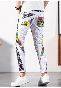 Detail view of men's slim fit jeans with colorful graffiti prints and street style patterns