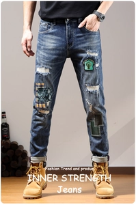 Close-up of slim fit distressed jeans with vintage patchwork and embroidery details