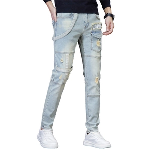 Slim fit men's distressed light blue jeans with patchwork details and ripped denim texture