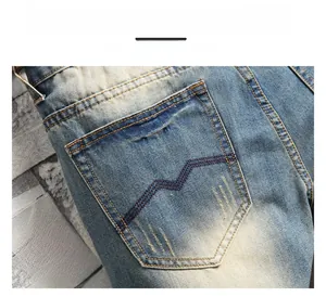 Detail of vintage washed blue jeans featuring classic double stitching on the back pocket