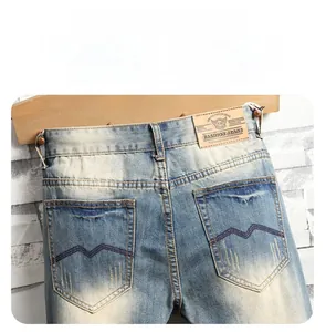 Detail of vintage blue jeans showing back pocket wave embroidery and brown leather waist tag