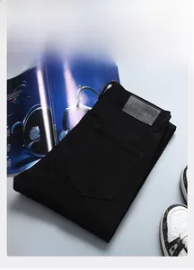 Gros plan d'un jean noir avec l'étiquette en cuir VERSKIE et la texture du tissu