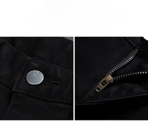 Gros plan sur un bouton en métal argenté et une fermeture éclair YKK sur jean noir ajusté