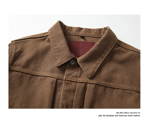 Detail view of the brown canvas jacket collar featuring a red woven label and sturdy stitching