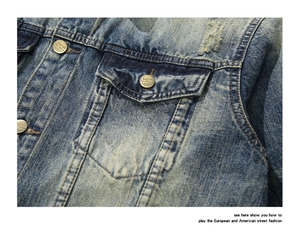 Close-up of vintage washed denim jacket with distressed ripped detail and bronze buttons