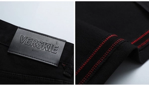 Détail d'un jean noir avec étiquette de marque en cuir et coutures rouges contrastées