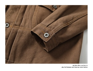 Detail of brown canvas jacket showing durable texture, metal buttons and contrast stitching