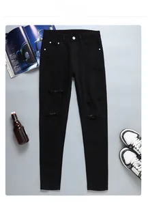 Détail du jean denim noir coupe slim avec genoux déchirés et jambes fuselées modernes