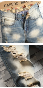 Detailed close-up of vintage washed blue denim with star pattern lining and ripped knee design