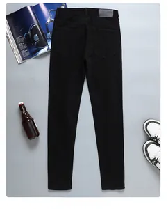 Vue arrière du jean noir slim avec cinq poches et écusson en cuir embossé à la taille