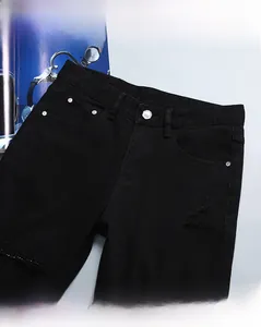 Détail de jean noir vieilli avec bouton en métal argenté et gros plan sur la taille