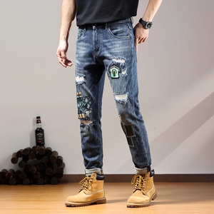 Men's slim fit distressed blue jeans with vintage patches and embroidery details
