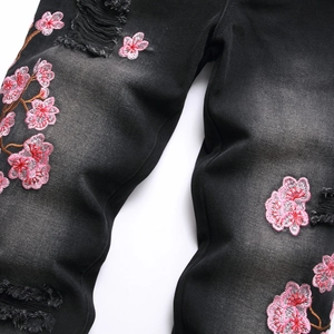 Men's street style black washed flare jeans with pink cherry blossom embroidery and ripped detail