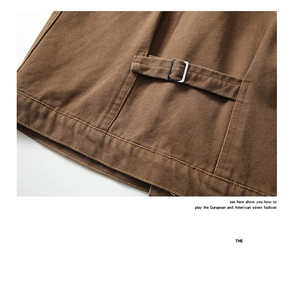 Detail of adjustable back waist strap with metal buckle on brown canvas jacket
