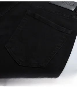 Détail de la poche arrière sur un jean noir slim avec écusson en cuir de qualité premium
