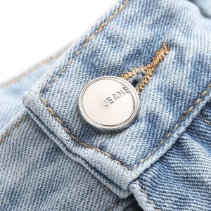 Men's blue flared jeans featuring graffiti patches and a vintage silver metal button detail