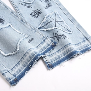 Men's blue flared streetwear jeans with star patches and artistic embroidery detail