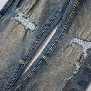 Vaqueros acampanados con lavado retro y detalles rasgados en la rodilla con costuras de contraste