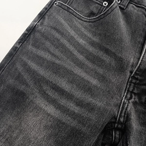 Close-up of black washed denim jeans featuring front pocket details and silver rivets