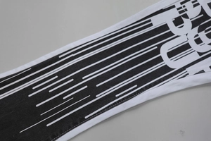 Detail view of denim fabric with bold black stripes and artistic printed lettering