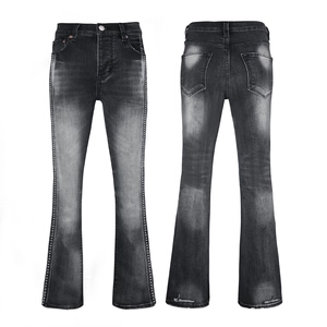 Detail view of washed black flared jeans with silver stud side accents and retro texture