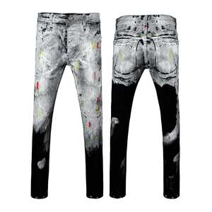 Dettaglio dei jeans slim bicolore neri e grigi con artistici schizzi di vernice colorata