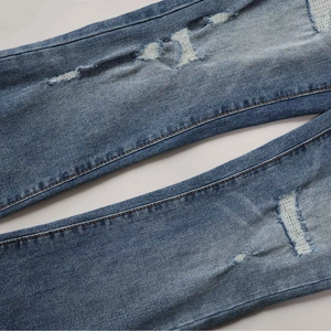 High-waisted stretch flare jeans in washed blue with embroidery and ripped details
