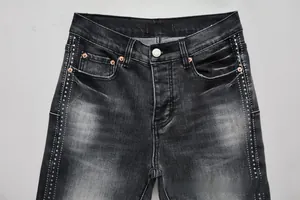 Close-up of black washed flare jeans featuring vertical side rhinestones and silver button