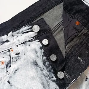 Detail of waist and button fly on slim fit black acid wash jeans with silver buttons