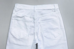 Detail view of white denim jeans rear waist with belt loops and symmetrical pockets